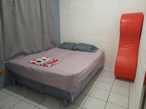 ein kleines Zimmer mit einem Bett und einem roten Objekt in der Unterkunft Apartamento 33 in Santa Ana