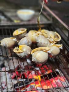 a bunch of food cooking on a grill at Đại Dương La Gi Homestay & Coffee in Lagi