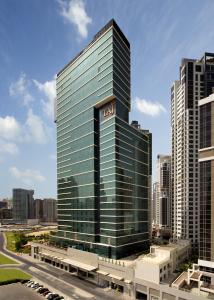 a tall building with a sign on the side of it at Taj Dubai in Dubai