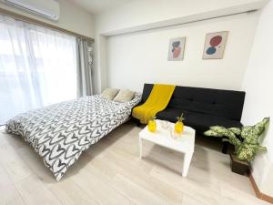 a bedroom with a large bed and a table at 北新宿 Central Shinjuku Walk to Kabuki-chou, Golden gai in Tokyo