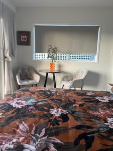a bedroom with a bed and a table and chairs at Sun and sea at manly in Whangaparaoa