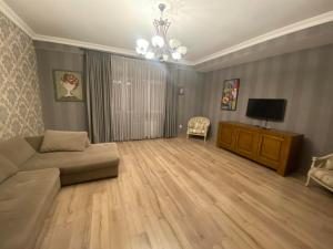 ein Wohnzimmer mit einem Sofa und einem TV in der Unterkunft Apartment Tbilisi View in Tbilisi City