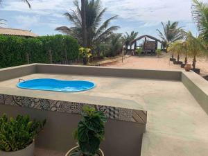 a swimming pool on top of a balcony with a blue tub at Bela casa de praia beira mar in Feliz Deserto