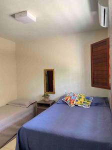 a bedroom with two beds with blue sheets and a mirror at Bela casa de praia beira mar in Feliz Deserto