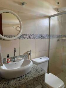 a bathroom with a sink and a toilet and a mirror at Bela casa de praia beira mar in Feliz Deserto