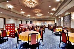 さいたま市にあるパレスホテル大宮のテーブルと椅子、シャンデリアのあるレストラン