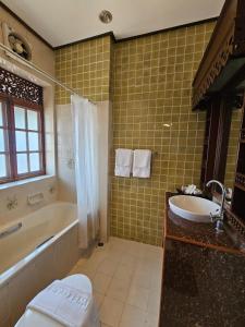 a bathroom with a tub and a sink and a bath tub at Malulee Homestay/Cafe/Massage in Lampang