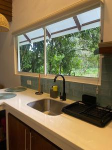 eine Küchentheke mit einem Waschbecken und einem Fenster in der Unterkunft Rossélodgevillas in Fortuna