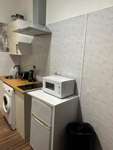 una pequeña cocina con microondas encima de una nevera en Premier Apartmetns Manchester, en Mánchester
