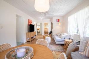 a living room with a couch and a table at Cosy Straddie cottage + sleeps 6 + close to beach in Point Lookout