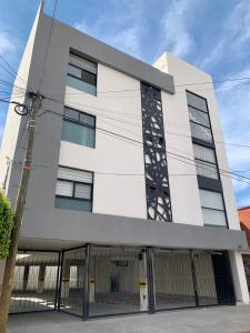 un edificio blanco con una valla delante en Cómodo Loft Tequis. Facturamos en San Luis Potosí