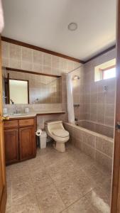 a bathroom with a toilet and a tub and a sink at La Casa de Cariari Al Golf in Heredia