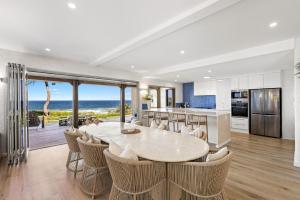a kitchen and dining room with a table and chairs at Saltwater Beach House in Yaroomba