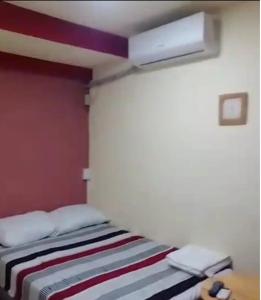 1 dormitorio con 1 cama con pared roja en Comfort Home Escalón en San Salvador