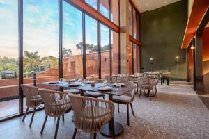 a restaurant with tables and chairs and large windows at Hotel Adam Krabi in Ao Nang Beach