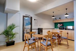 a room with a table and chairs and a kitchen at HUBS Hostel Yogyakarta in Yogyakarta