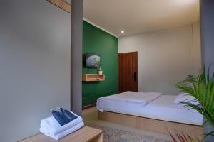 a bedroom with a bed and a green wall at HUBS Hostel Yogyakarta in Yogyakarta
