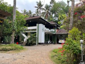 a house with a car parked in front of it at Maliyeckal Homestay in Munnar