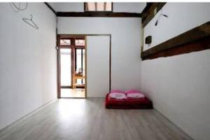 a room with a red bed in the middle of a room at Moran Guesthouse in Jeonju