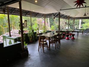 un coin repas avec une table, des chaises et des plantes dans l'établissement Maliyeckal Homestay, à Munnar
