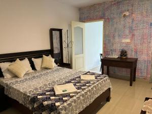 um quarto com uma cama grande e uma mesa em Maliyeckal Homestay em Munnar