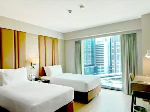 a hotel room with two beds and a large window at Ramada by Wyndham Bangkok Sukhumvit 11 in Bangkok
