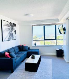 a living room with a blue couch and a coffee table at Aqualine Apartments On The Broadwater in Gold Coast