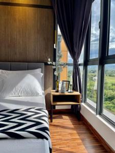 um quarto com uma cama, uma mesa e janelas em K Avenue Modern Style Studio (5 Mins to Airport) em Kota Kinabalu