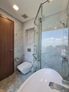 a bathroom with a tub and a shower and a toilet at Vinhomes Central Park Apartment- Landmark Luxury in Ho Chi Minh City