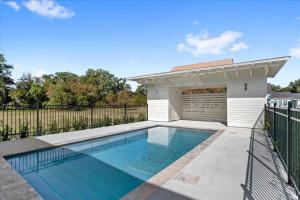 a swimming pool in front of a building with a garage at Cat Island Town Home in Pass Christian