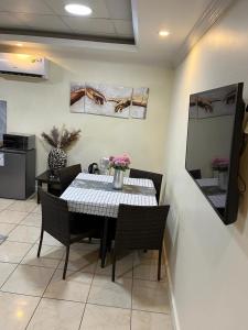 uma sala de jantar com uma mesa e cadeiras com flores em Mikocheni smart apartment em Dar es Salaam