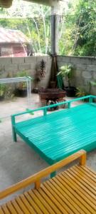 a green table and a bench on a patio at pulau weh sabang marifi in Paya