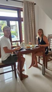 a man and a woman sitting at a table at Regno Villa the Infinity by Nflix in Panadura