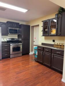 a kitchen with black cabinets and stainless steel appliances at Cozy Home with Sparkling Pool/Pet Friendly in Mesa
