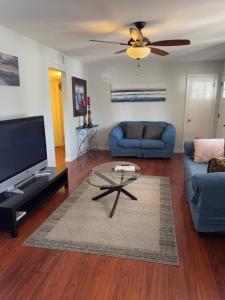 a living room with a blue couch and a tv at Cozy Home with Sparkling Pool/Pet Friendly in Mesa