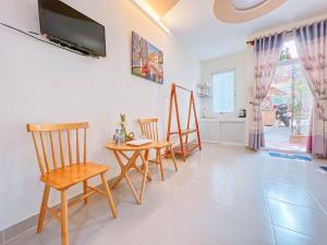 a living room with a table and chairs and a tv at Mui Ne Sunlight Villa in Mui Ne