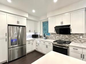a kitchen with white cabinets and stainless steel appliances at Casa Dolce Vita - Luxury Modern Stays - Flexible Monthly Arrangements Available 30-Night Minimum in Irvine