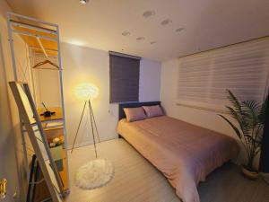 a bedroom with a bed and a lamp in it at Terrace House Hwagok station in Seoul