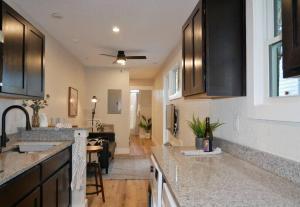a kitchen with black cabinets and a living room at Hip Container APT - 5 Min Walk to TIAA Bank in Jacksonville