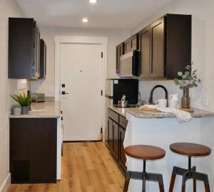 a kitchen with two bar stools and a counter top at Hip Container APT - 5 Min Walk to TIAA Bank in Jacksonville