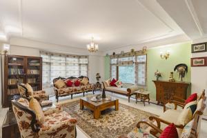 西姆拉的住宿－Alaya Stays Meridian Oak, Shimla，带沙发和桌子的客厅
