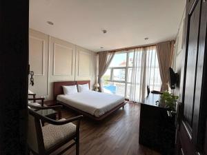 カントーにあるKim Tho Hotelのベッドと大きな窓が備わるホテルルームです。