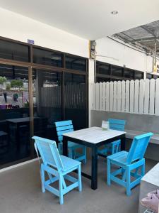 a table and blue chairs on a patio at Labella samet guesthouse in Ko Samed