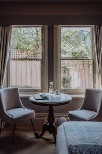 Pokój z 2 krzesłami i stołem oraz 2 oknami w obiekcie Grande Vue w mieście Hobart