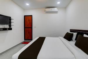 1 dormitorio con 1 cama grande y TV en OYO Flagship Hotel MK Palace, en Lucknow