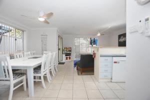 uma cozinha e sala de jantar com uma mesa branca e cadeiras em Bennett's Beach House em Hawks Nest