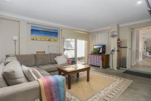 uma sala de estar com um sofá e uma mesa em Bennett's Beach House em Hawks Nest
