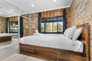 a bedroom with a large bed and a brick wall at Family Getaway in Salt Ash in Salt Ash