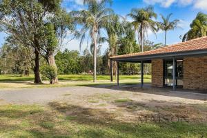 a brick building with palm trees in the background at Family Getaway in Salt Ash in Salt Ash