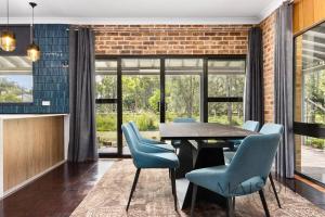 a dining room with a table and blue chairs at Family Getaway in Salt Ash in Salt Ash